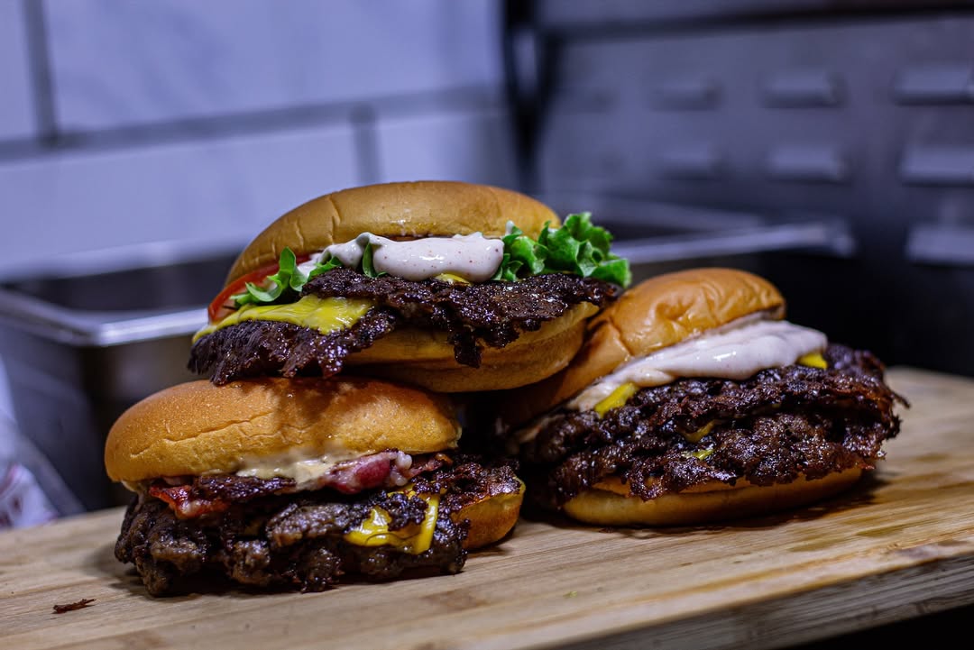 Trois smash burgers en cuisine